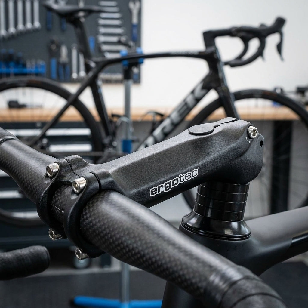 Ergotec AHEAD Vorbau High Charisma Alu schwarz, montiert an Carbon-Rennradlenker, Werkstatt im Hintergrund.