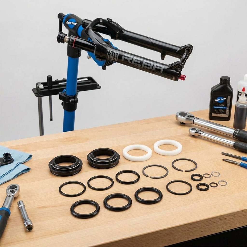 RockShox Reba Federgabel Service-Kit: Dichtungen, O-Ringe und Werkzeuge zur Wartung auf Werkbank.