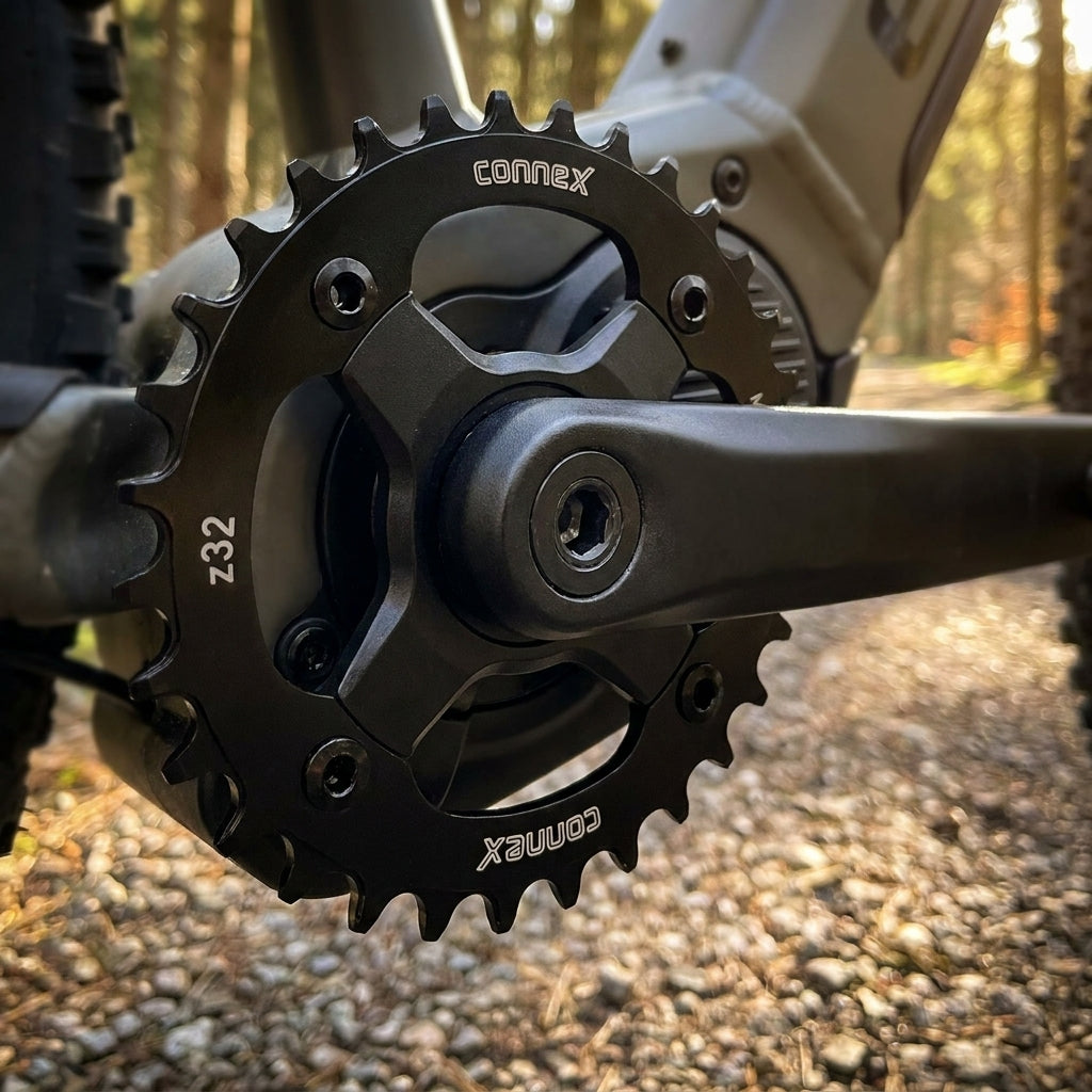 Schwarzes ConneX E-Bike Kettenblatt 32 Zähne an E-Bike Kurbel im Wald.