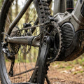 KMC E1 EPT E-Bike Kette an Mittelmotor und Kurbelgarnitur, mit Wasser und Schlamm bedeckt, im Wald.