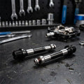 Xpedo Achsenkit für Trident Pedal (XMX28AC) Ersatzteilset auf Werkbank mit Pedal und Werkzeug.