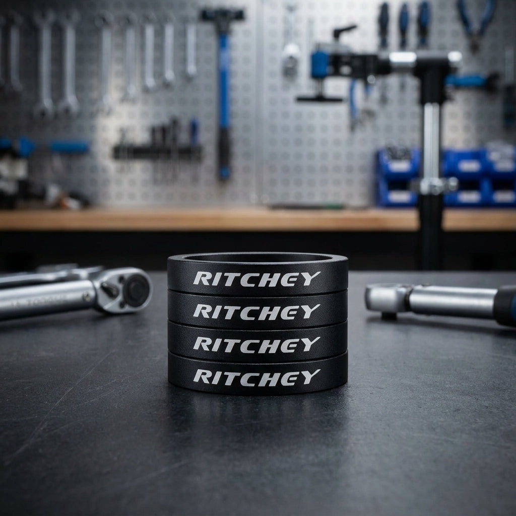 Vier schwarze Ritchey 1 1/8 Zoll 5mm Fahrrad Spacer auf Werkbank mit Werkzeugen im Hintergrund.
