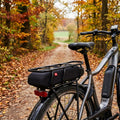 Fahrer Akkuschutz für Shimano Steps E6000 Gepäckträgerakku am E-Bike im Herbstwald.
