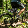 Schwarzer Selle SMP Junior Well Unisex-Sattel am Mountainbike auf Waldweg.