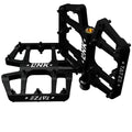 Schwarze Tatze LINK MTB Titan Plattformpedale mit 10 Pins pro Seite auf weißem Hintergrund.