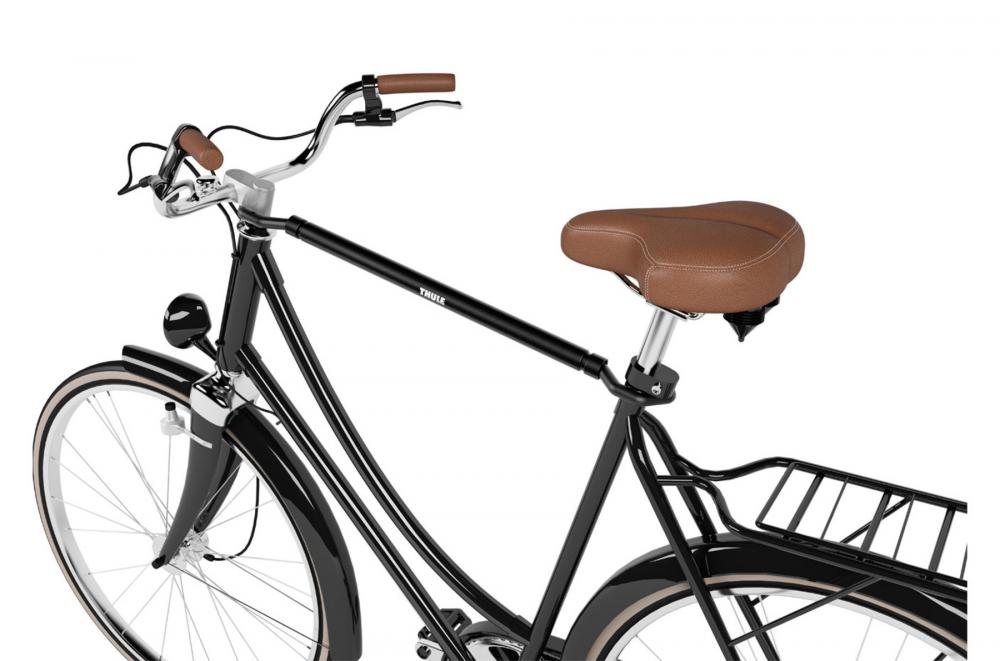 Thule Bike Frame Adapter montiert an einem schwarzen Fahrrad zwischen Sattelstütze und Lenker für den Transport.