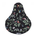 Basil Sattelüberzug Wanderlust charcoal mit buntem Vogel- und Blumenmuster für Fahrräder.