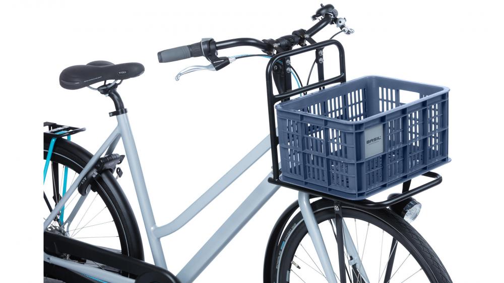 Hellblaues Fahrrad mit Basil Transportkorb Crate S Bluestone 17L vorne montiert.