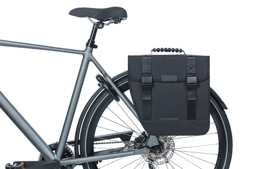 Schwarze Basil Tour Single Fahrrad-Gepäcktasche 14l links am grauen Fahrrad, wasserabweisend, für Pendler & Touren.