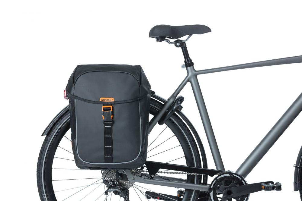 Basil Miles MIK 2.0 wasserdichte Doppeltasche mit Rollverschluss und Reflex am grauen Fahrrad.