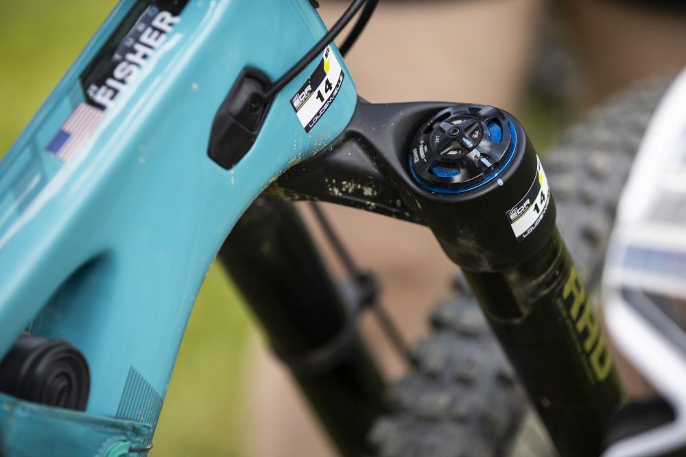 Detailansicht FOX INV Podium Factory Enduro-Federgabel mit blauen Einstellern am teal Mountainbike.