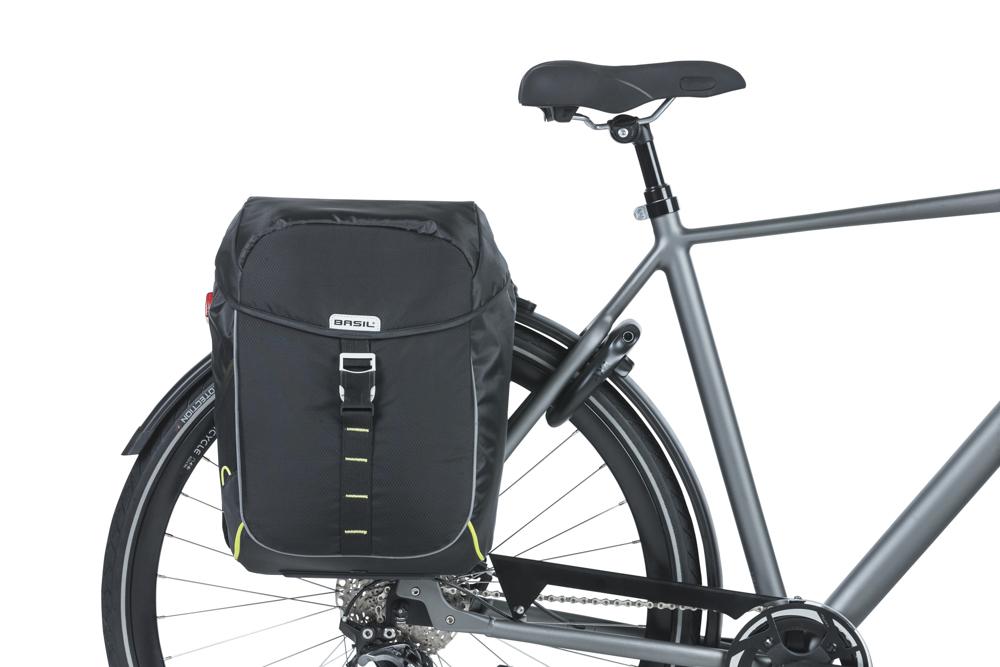 Basil Miles Doppelpacktasche schwarz lime, wasserdicht, 34l, am Hinterrad eines grauen Fahrrads montiert.
