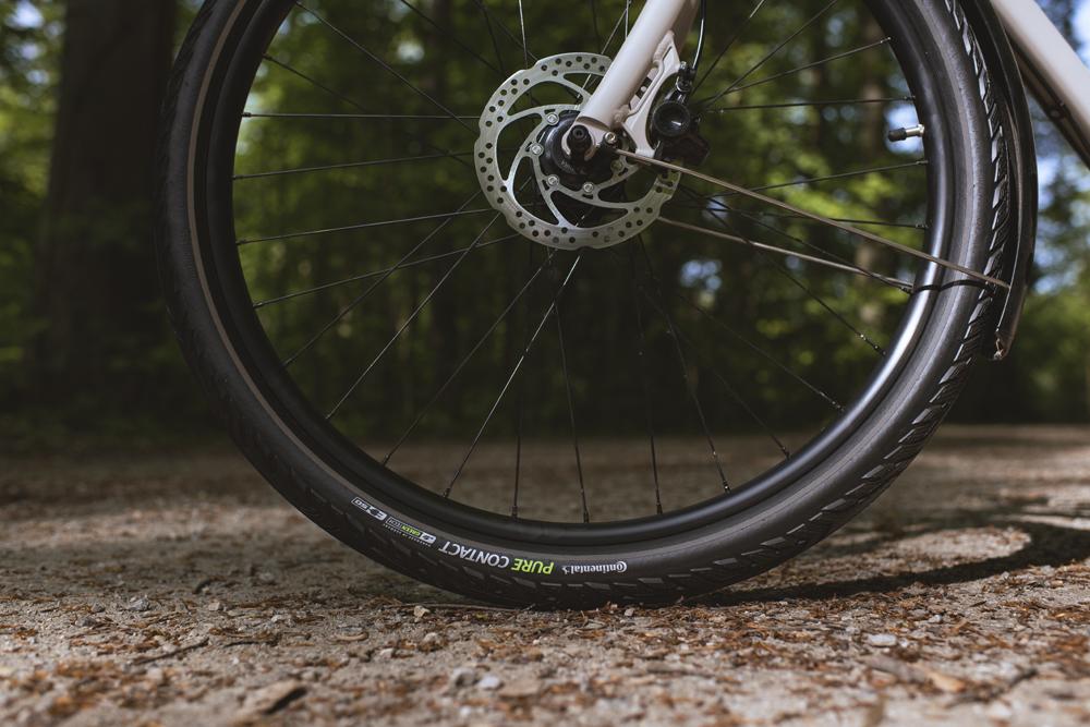 Continental Pure CONTACT Faltreifen 27.5x2.00 mit Pannenschutz am Fahrrad auf Schotterweg im Wald.