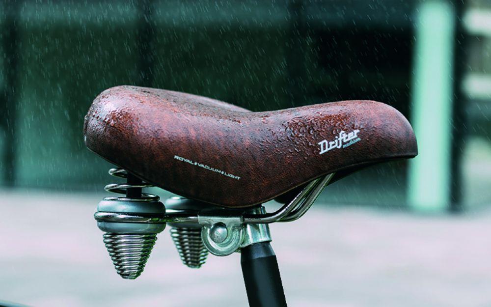 Brauner Selle Royal Drifter Fahrradsattel mit Doppelfedern im Regen, wasserdichtes Vintage-Design für Citybikes.