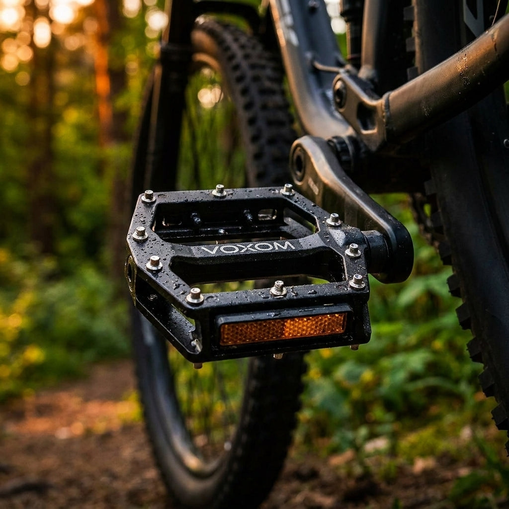 Voxom Pe9 MTB Pedal schwarz mit Reflektor, nass am Mountainbike auf Waldweg.