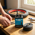 Impac Fahrradschlauch 16 Zoll AV 35 mm auf Holztisch mit Fahrradreifen und Werkzeug.