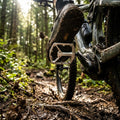 Crankbrothers Stamp 2 großes silbernes Plattform-Pedal an matschigem Mountainbike im Wald.
