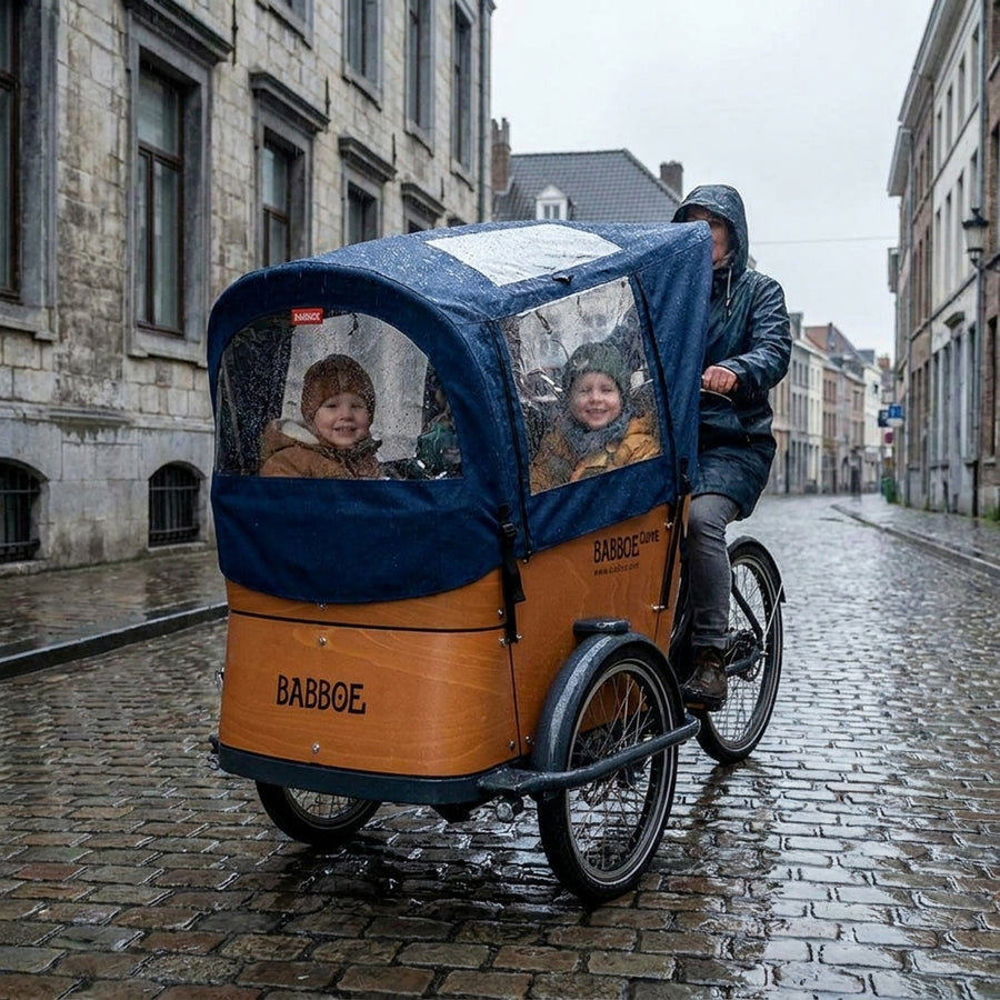 Babboe Curve Lastenrad mit blauem Regenverdeck. Schützt Kinder zuverlässig vor Regen und Wind. Perfekt für Familien bei jedem Wetter.