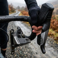 SRAM Apex 12-fach Flat Mount Scheibenbremse vorn am Fahrrad bei Nässe mit Hand am Hebel.