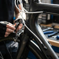 Techniker montiert weißes SRAM SlickWire Pro Schalt-/Bremskabel-Kit an einem Carbon-Rennrad.
