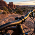 Fahrradlenker Contec Moab schwarz mit Tautropfen im Morgenlicht vor Felsformationen.