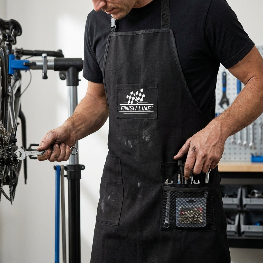 Finish Line Werkstattschürze schwarz, verstellbar, mit Hüft- & Mesh-Taschen, robust für Fahrradwerkstatt, Profi-Qualität.