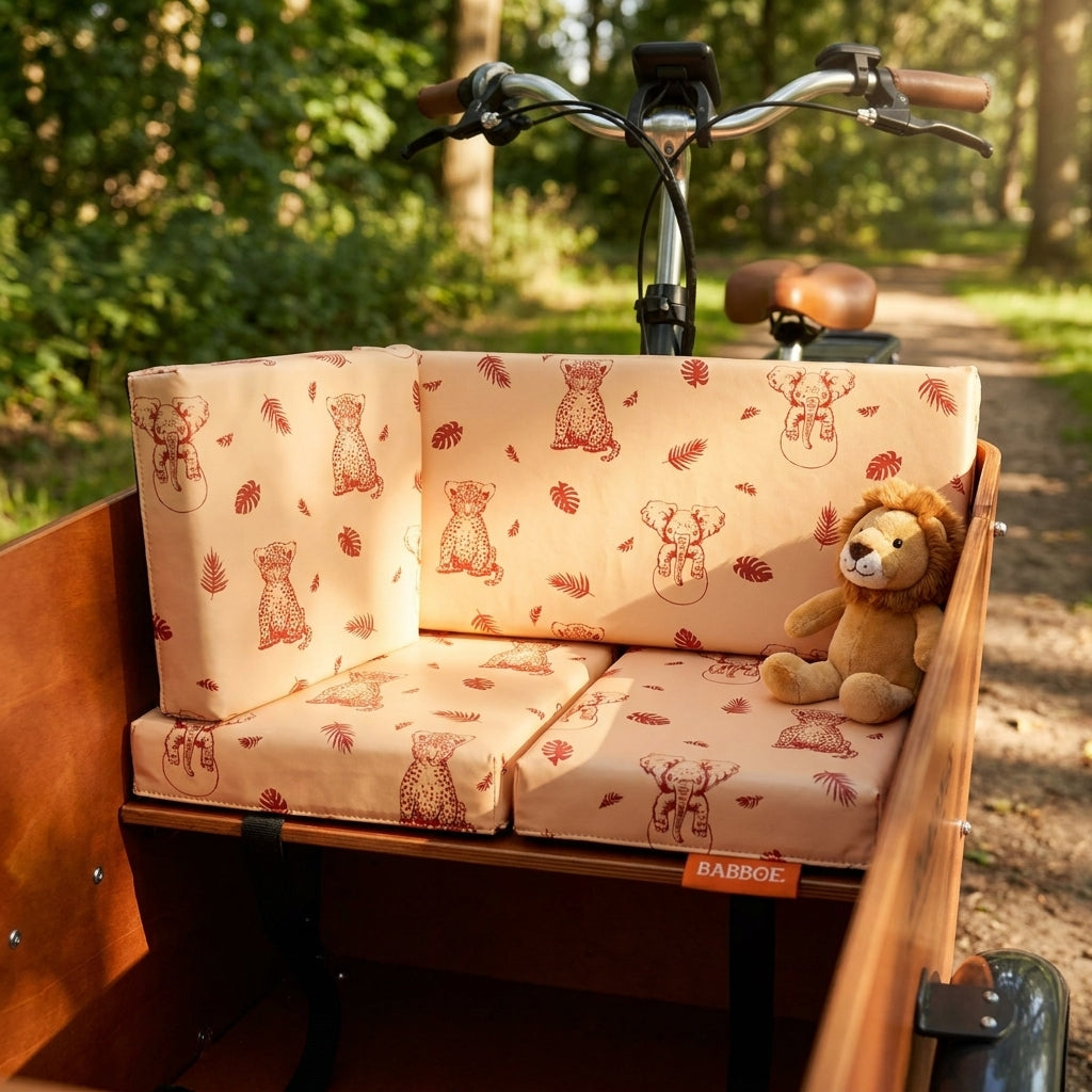 Kissenset Babboe Safari Peach für Max-E Lastenrad mit Tier- und Blättermuster auf hellrosafarbenen Polstern.