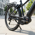 Detailansicht schwarzes E-Bike, Bosch Performance Cruise Motor. Kettenschutz Curana, Hinterrad, Gepäckträger.