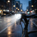 UNION E-Bikebeleuchtung 50 Lux vorn, hell leuchtend im Regen auf nächtlicher Straße.