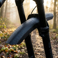 Rockshox Rudy Steckradschutz Fender schwarz, nass mit Tropfen, am Mountainbike auf Waldweg.