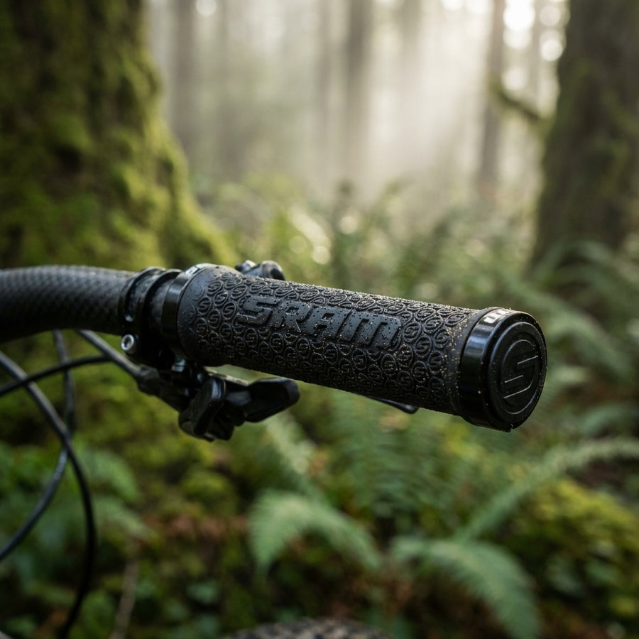 SRAM MTB Lockring Griffe schwarz mit Logo-Profil beidseitig klemmbar am Mountainbike-Lenker in einem Wald.