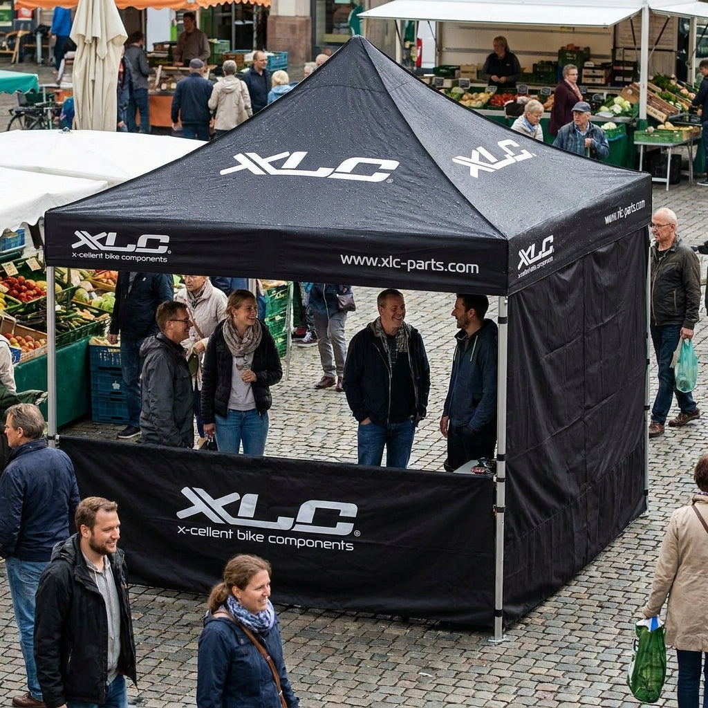 XLC schwarzes 3x3m Faltzelt mit Seitenwand und Logo auf belebtem Marktplatz.