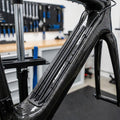 SHIMANO Kabelabdeckung schwarz für Di2 Kabelgehäuse am Carbon-Fahrradrahmen in der Werkstatt.