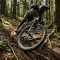 Robustes DT Swiss E 1900 SPLINE 29" Enduro-Vorderrad am Mountainbike auf schlammigem Waldweg.
