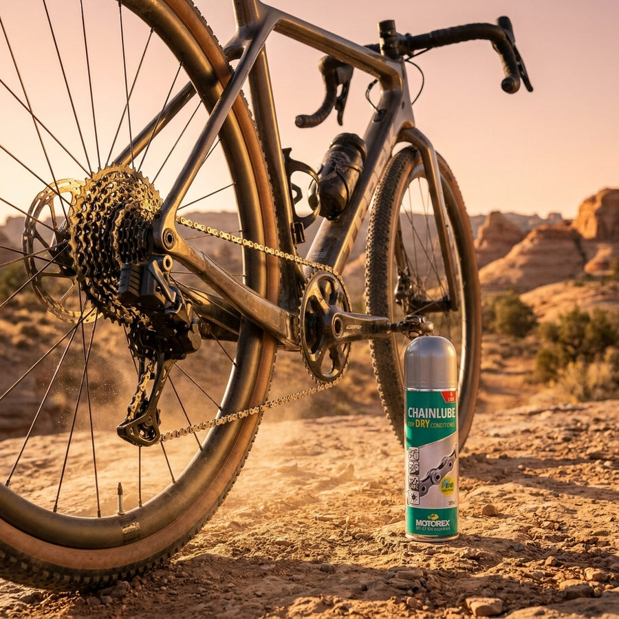 Motorex Chainlube Dry Conditions 300ml vollsynthetisches Kettenöl neben Gravelbike in trockener Wüstenlandschaft.