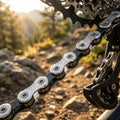 KMC X-12 silber/schwarz 12s Fahrradkette am Mountainbike-Schaltwerk im Gelände bei Sonnenuntergang.