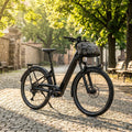 Schwarzes Centurion Country R2000 E-Bike auf Kopfsteinpflaster im Sonnenlicht, mit Fronttasche, komfortables City- & Trekking