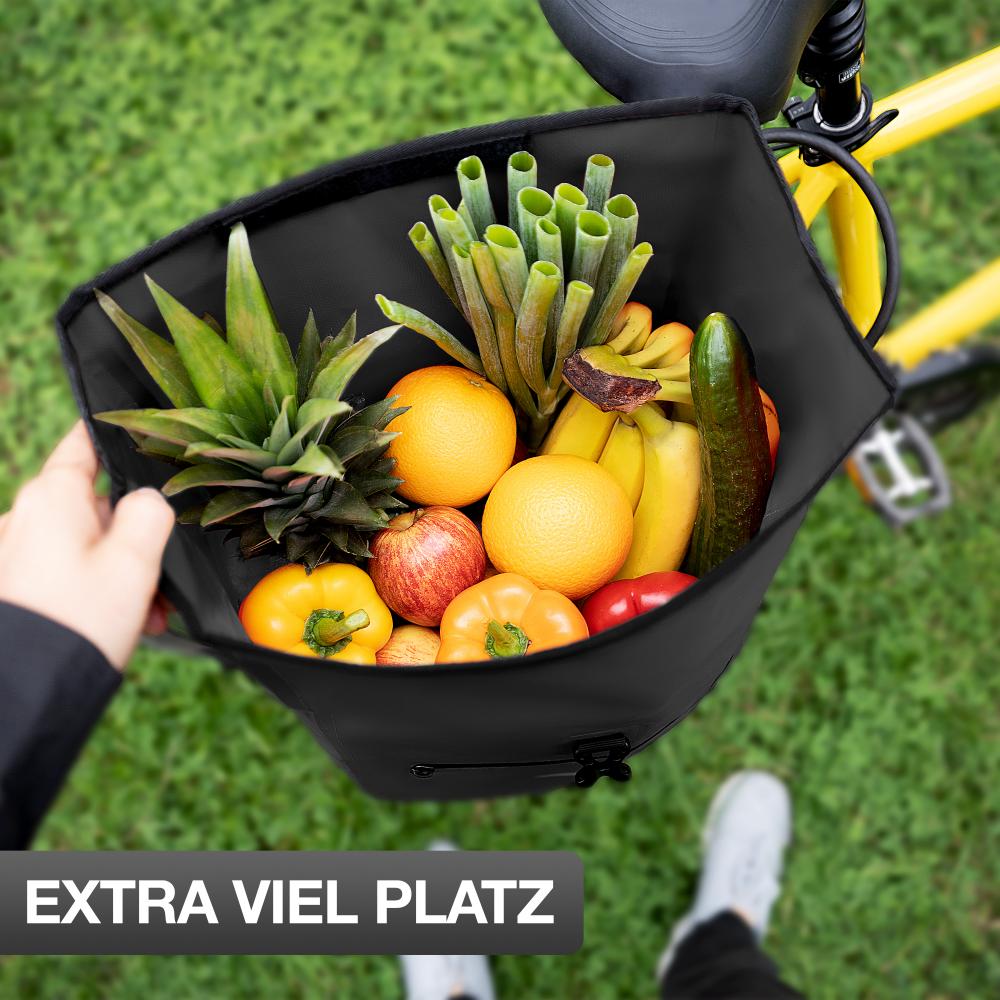 Valkental ValkBasic schwarze 28L Gepäckträgertasche am Fahrrad prall gefüllt mit frischem Obst und Gemüse.