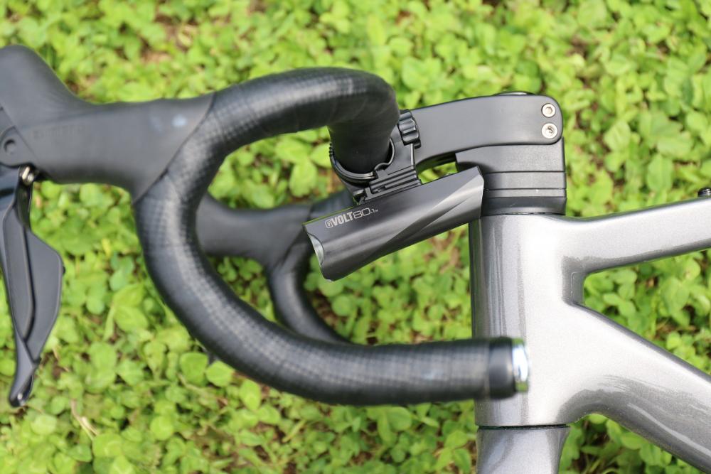 CATEYE GVOLT80.1 80 Lux Fahrradlampe am Lenker eines grauen Fahrrads. Kompakte Frontleuchte.