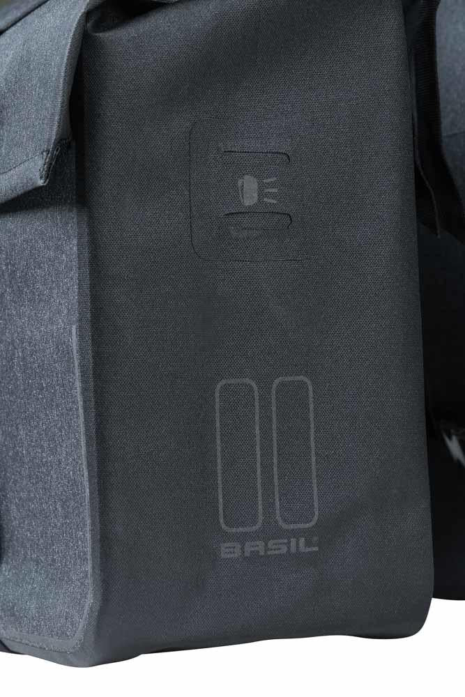 Detailansicht einer anthrazitfarbenen Basil Urban Dry Doppeltasche mit sichtbarem Logo und Reflektor-Symbol.