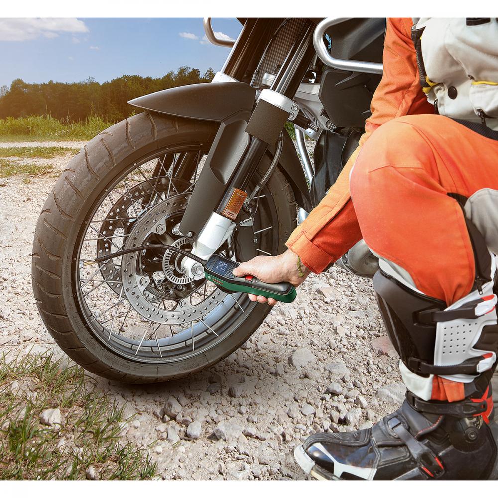 Person pumpt Motorradreifen mit Bosch EasyPump Akku-Druckluftpumpe kabellos auf.