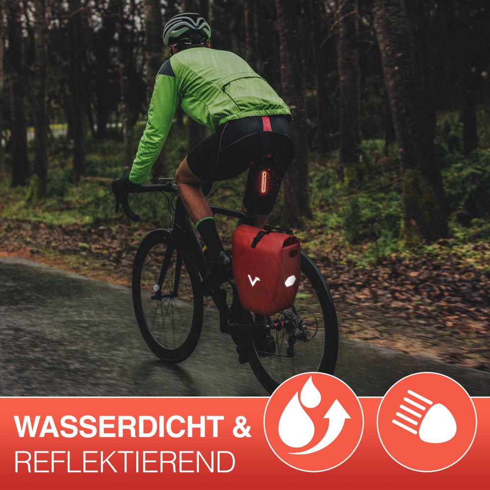 Valkental Gepäckträgertasche ValkBasic rot 20L am Fahrrad, wasserdicht & reflektierend, beim Radfahren im Wald.