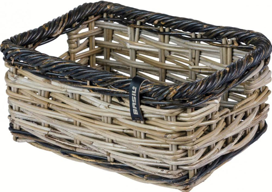 Basil Dijon S Vorderradkorb aus grau-schwarzem, grob geflochtenem Rattan mit Basil-Logo.