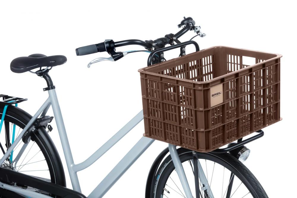 Braune Basil Crate L Fahrradkiste (40L, recycelter Kunststoff) auf dem Frontgepäckträger eines Damenrads.