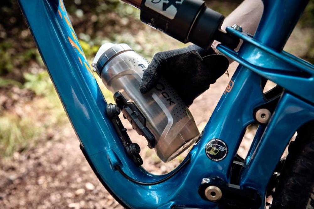 Fidlock TWIST Trinkflasche 590ml mit Bike Base am blauen Fahrradrahmen. Magnetisches Haltersystem für enge Rahmen.