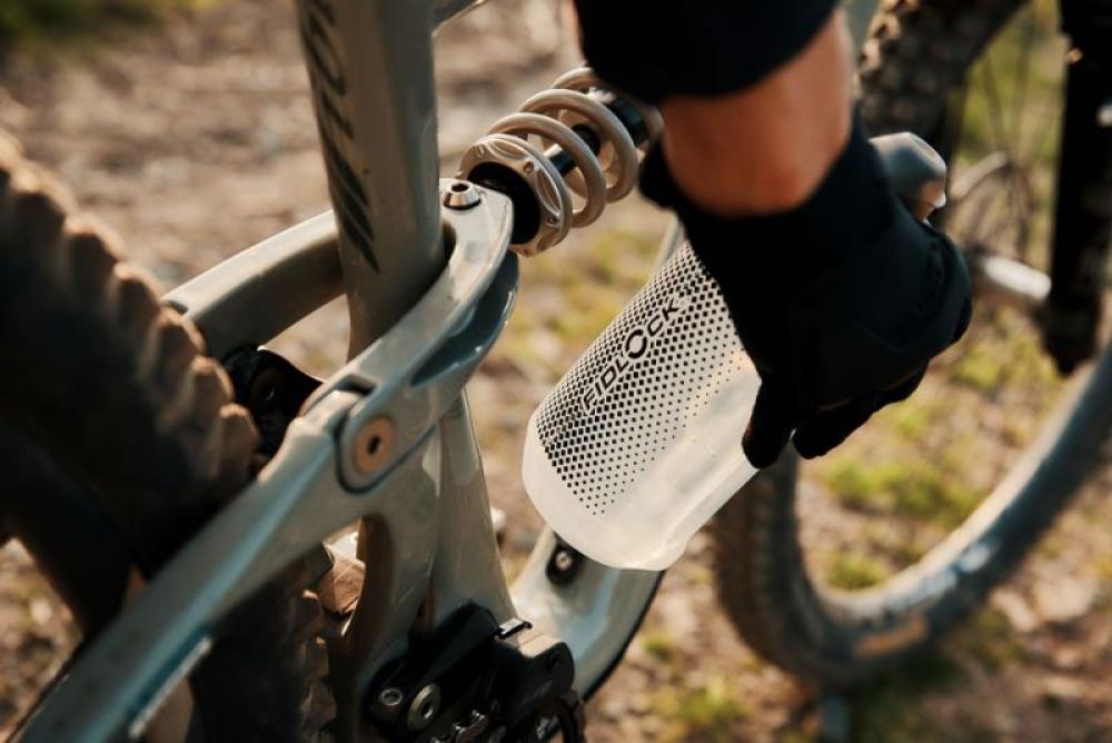 Hand befestigt kompakte FIDLOCK TWIST Bottle 750ml magnetisch an engem MTB-Rahmen mit Federung.