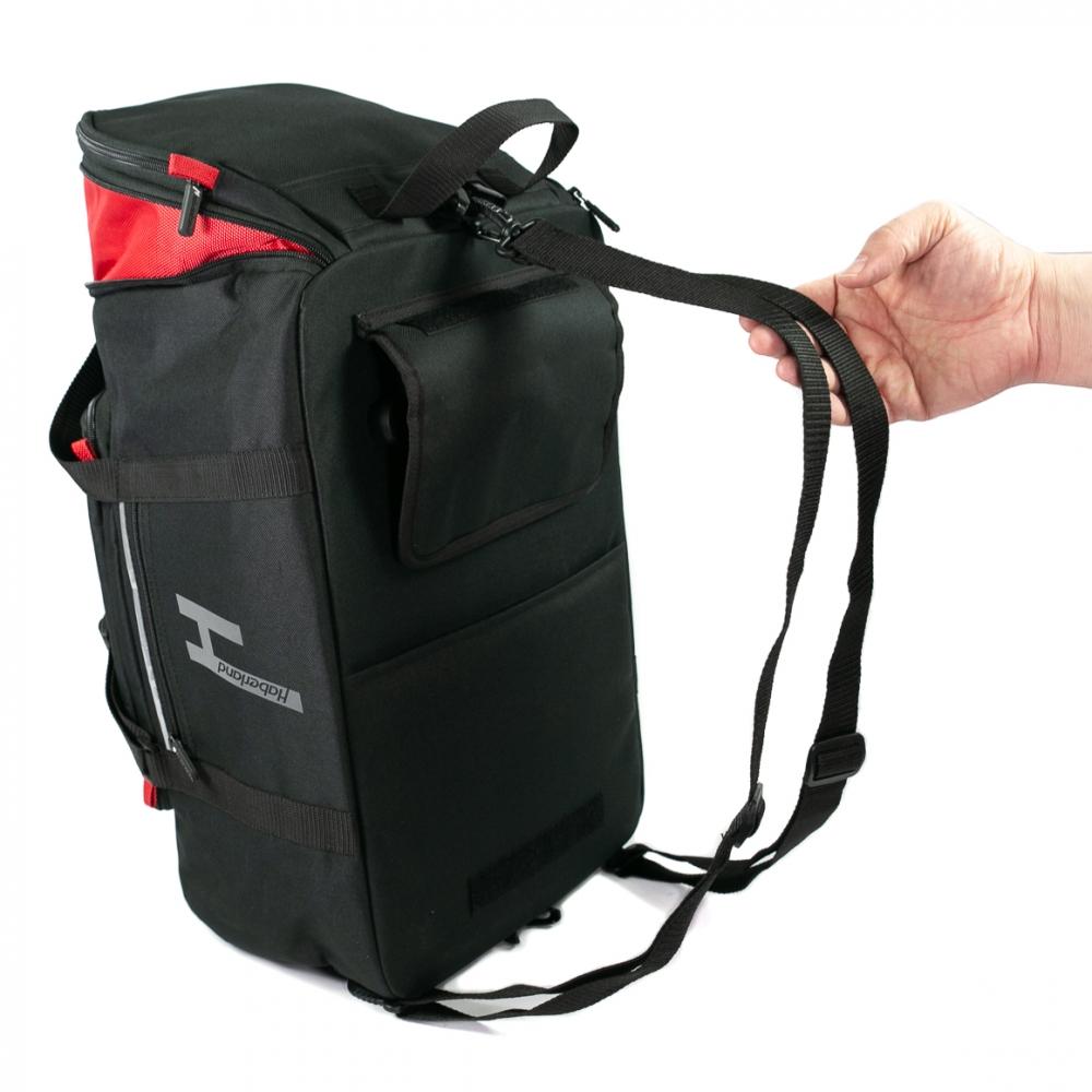Haberland TranSPORTer Fahrradtasche schwarz mit Rucksackfunktion, rot akzentuiert, wird von Hand gehalten.