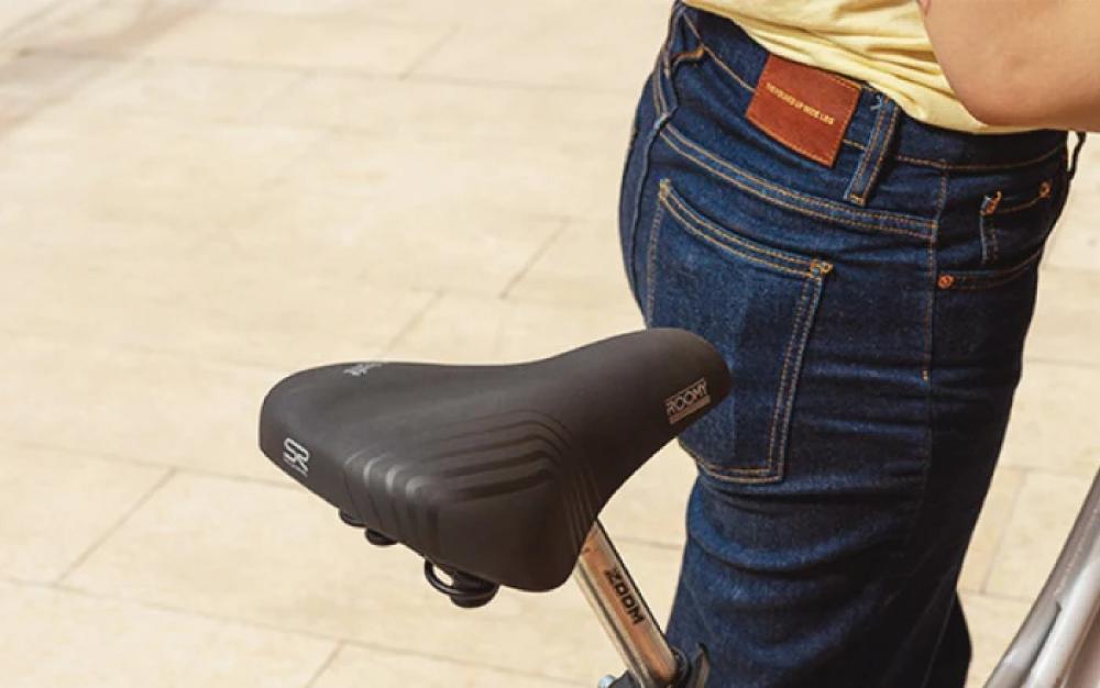 Schwarzer Selle Royal Roomy Moderate Unisex Fahrradsattel auf einem Fahrrad mit einer Person in Jeans.