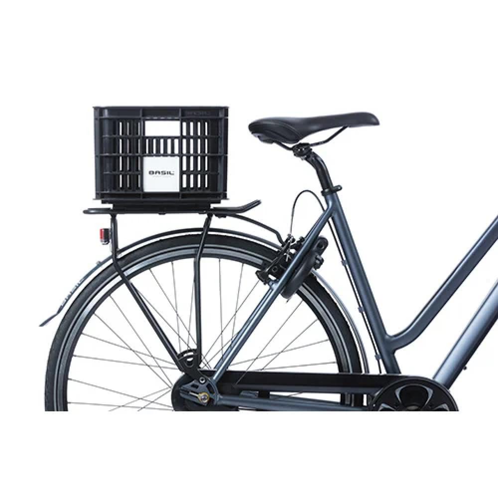 Schwarze Basil Crate S Fahrradkiste 17,5L aus recyceltem Kunststoff auf einem Fahrradgepäckträger montiert.