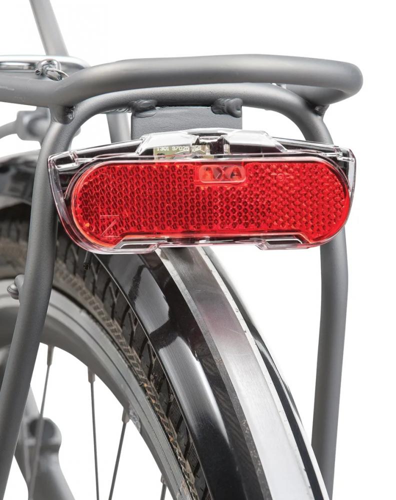 Rotes AXA LED-Dynamo-Rücklicht Slim Steady, schmal, am Fahrradgepäckträger montiert.